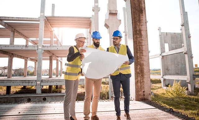 three construction workers looking at the building plan