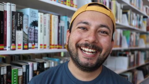 Sheridan Cazarez in front of shelf of library books