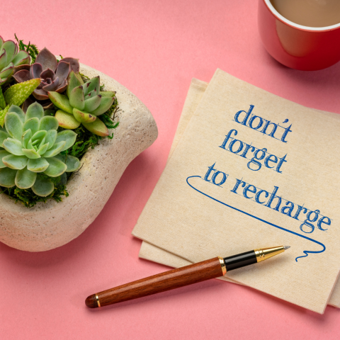 note on desk that reads "don't forget to recharge"