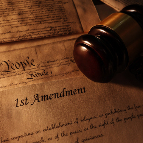 gavel rests on top of old document with a title of "first amendment"