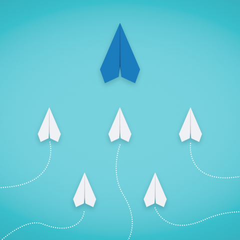 blue paper airplane being followed by smaller white paper airplanes