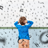 A child with hands on their head looks at a wall covered in falling letters.