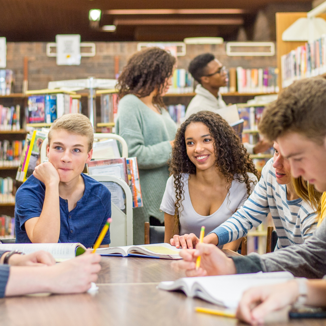 teens hanging out at a table in the library