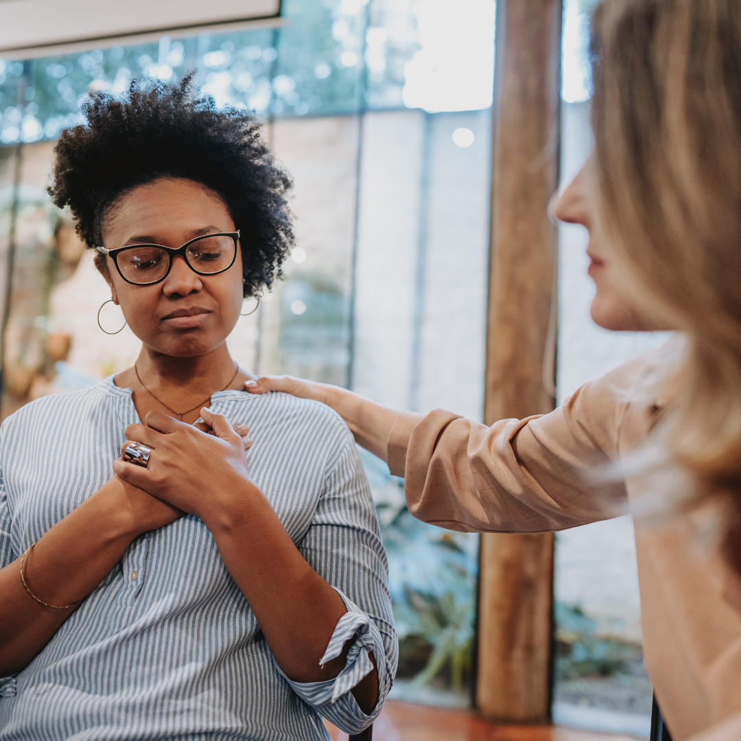 woman being comforted by another woman