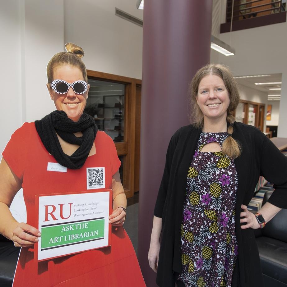 Megan Lotts posing with a cardboard cutout of herself